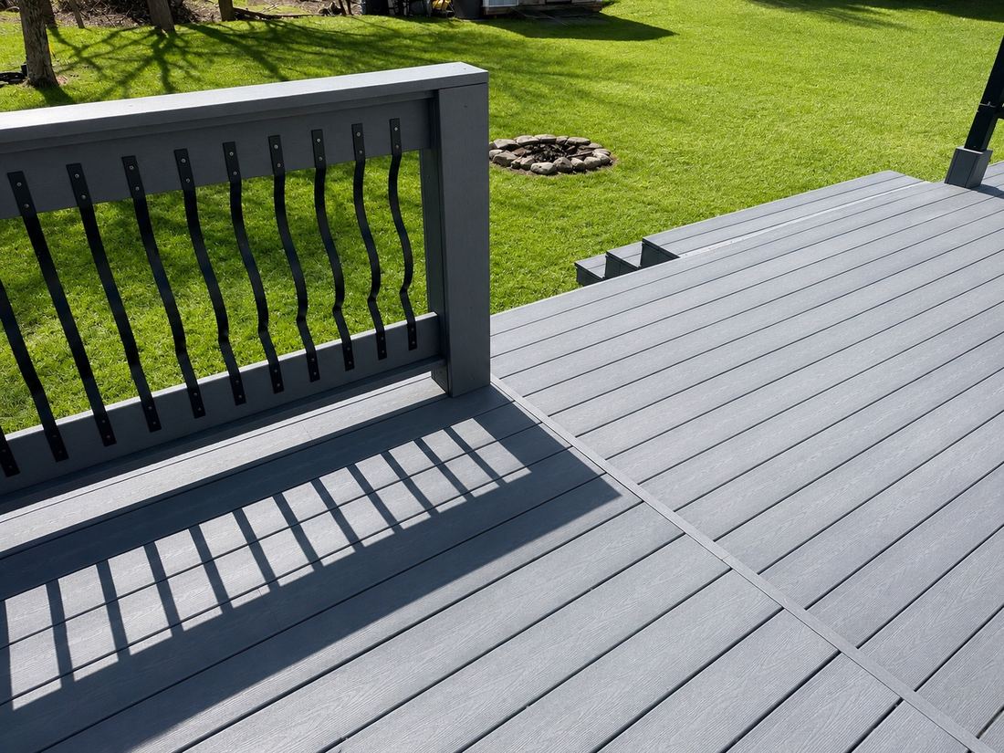 Finished deck in light grey recycled plastic lumber with a matching railing, looking along the board run