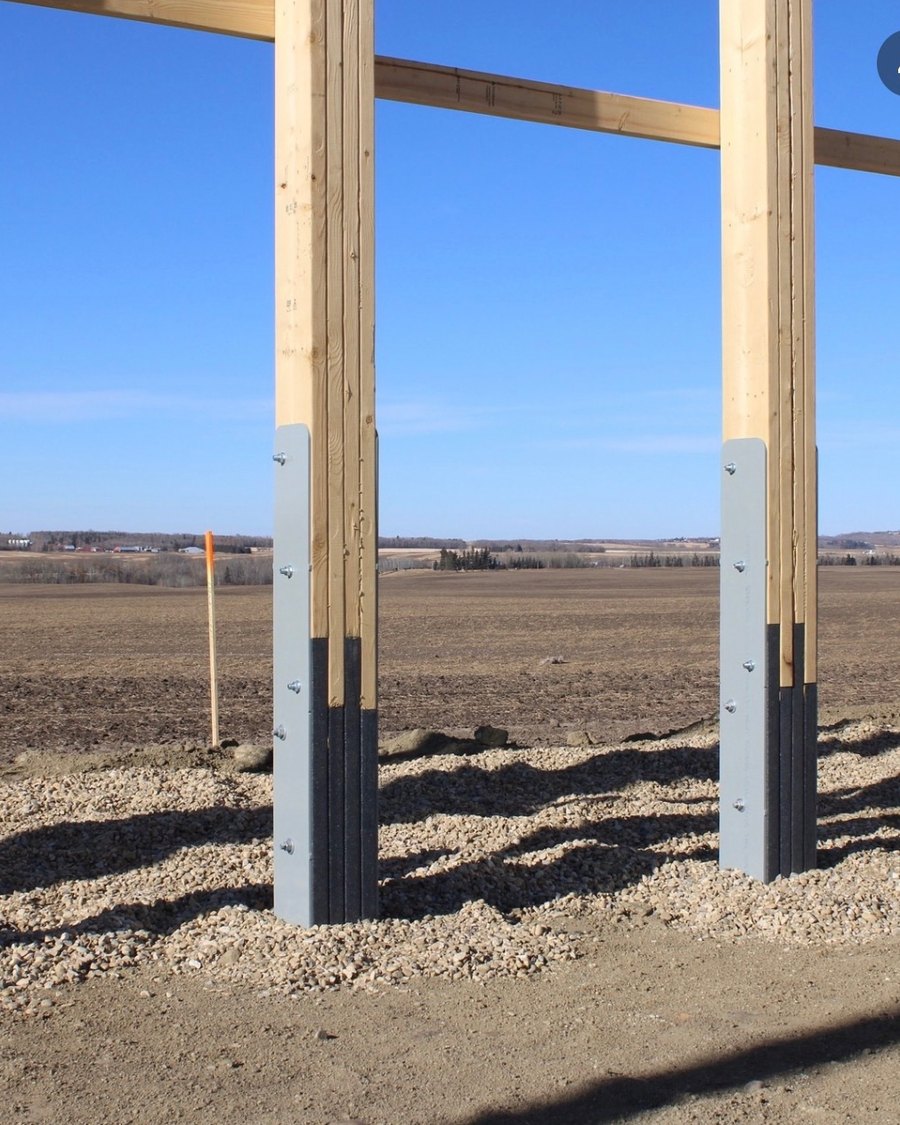 Eco Column recycled plastic post-frame column set in the ground before a shop build