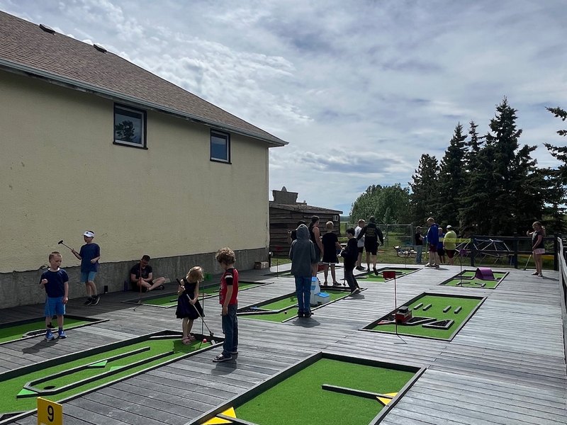 Children playing on a mini-golf course decked in recycled plastic lumber