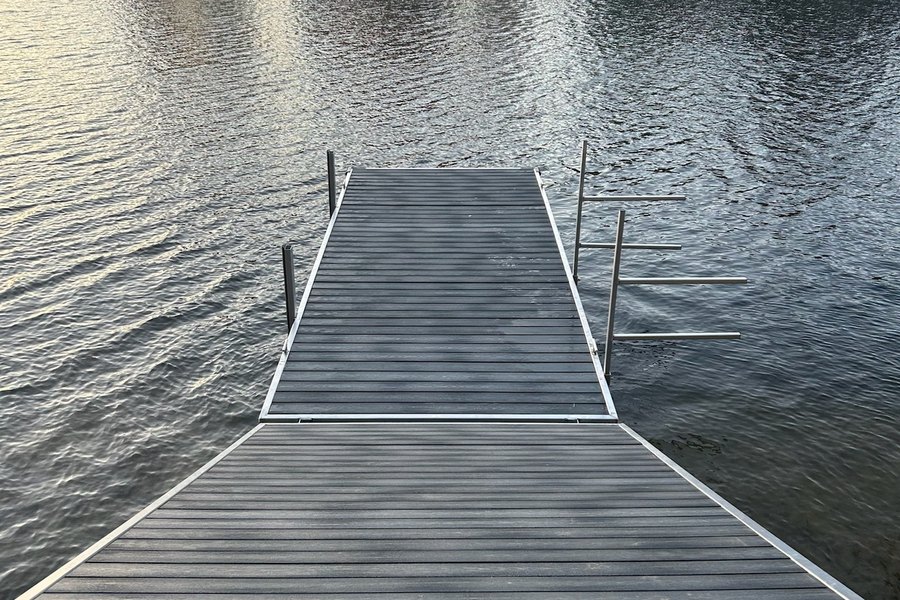 A recycled plastic lumber dock running out into a lake at dusk